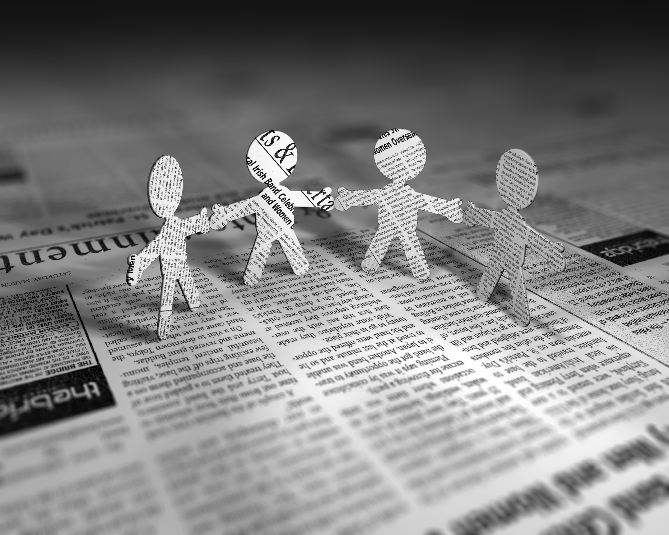 newspaper cutout people holding hands